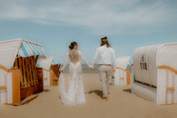 Braut und Bräutigam am Meer von Travemünde zwischen Strandkörben. Gefühlvolle Brautpaarfotografie in Scharbeutz und Umgebung.!