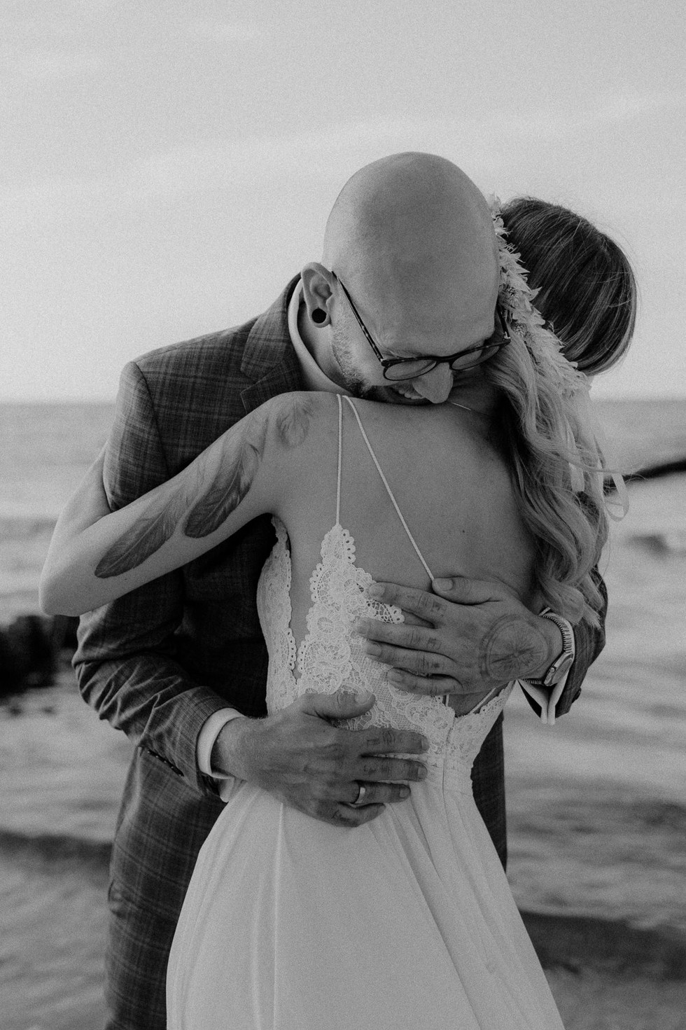 Pärchen hält sich liebevoll im Arm - im Hintergrund ist die Ostsee zu sehen. Gefühlvolle After Wedding Fotografie in Prerow und Zingst.