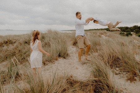 Vater spielt mit seinen Kindern in den Dünen auf Fischlanddarss. Ausgelassenes Familienshooting Graal Müritz.