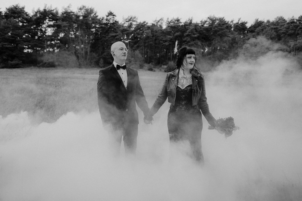 Fotoshooting mit Rauchbomben in Lütow auf Usedom. Verliebtes Pärchen steht händehaltend in den Wiesen, hinter ihnen zieht Rauch vorbei.