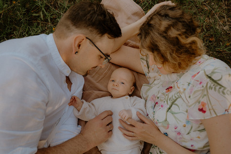 Eltern kuscheln mit ihrem Neugeborenen auf einer Decke in Rostock. Monique eure Babyfotografin in Rostock und Umgebung. 