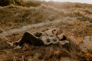 Fotograf für Paare in Wustrow : Pärchen liegt im Sonnenuntergang in den Dünen.