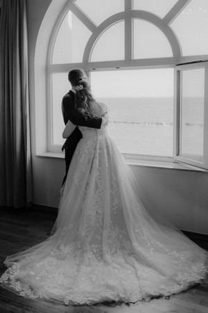 Standesamtliche Hochzeit auf der Seebrücke Sellin mit Meerblick. Brautpaar genießt Moment der Ruhe beim Paarshooting an der Ostsee in MV.