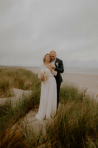Paar steht bei Regen in den Dünen auf Fischland Darss: Regenhochzeit in Zingst.