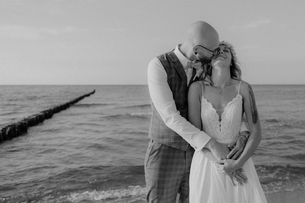 Romantisches Paarshooting am Meer auf dem Darß. Pärchen liegt sich zärtlich im Arm.