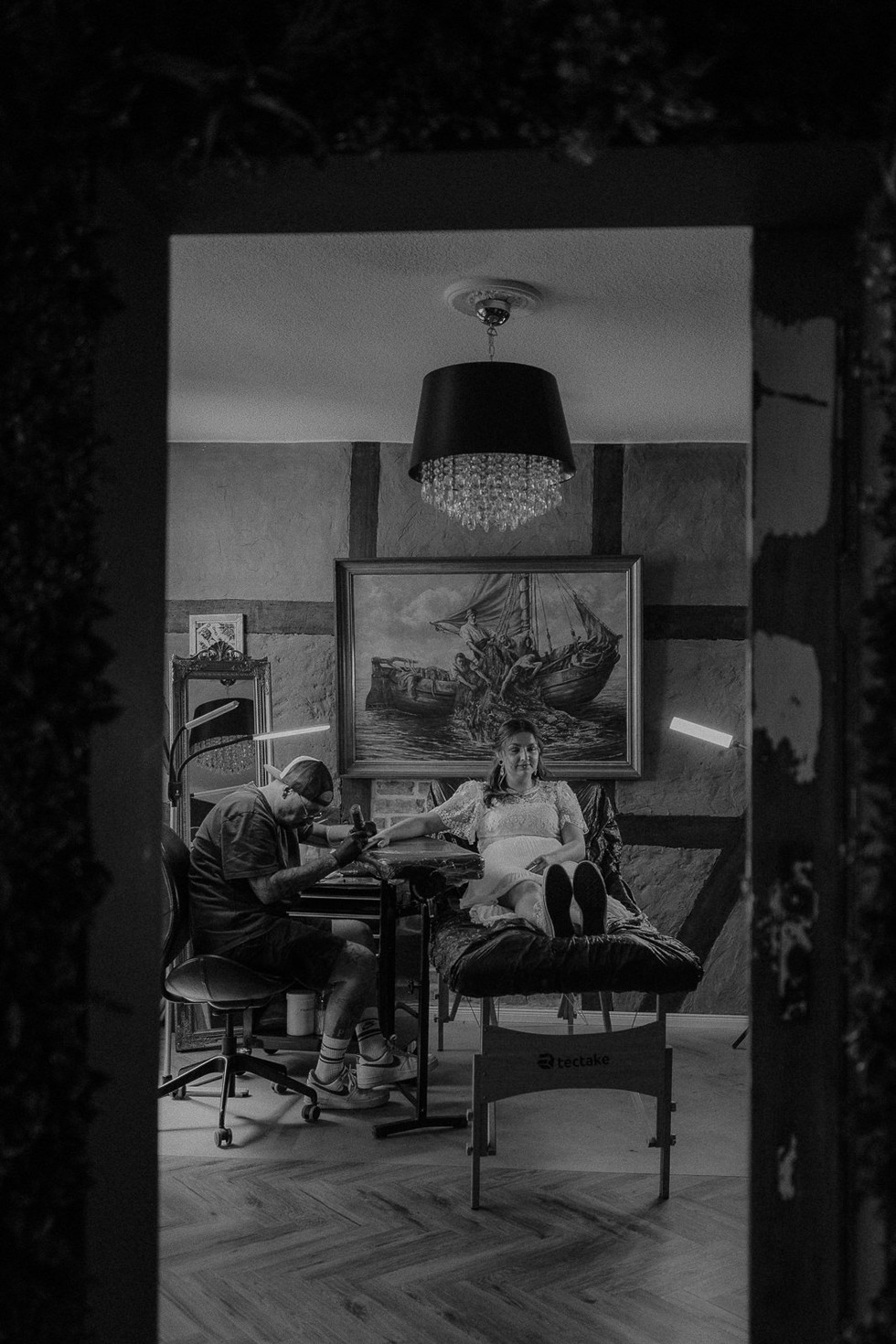 Stimmungsvoller Moment in einem Tattoostudio auf Usedom. Fotografin begleitet Brautpaar beim Tätowieren ihrer Ringe.