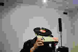A man covering his head with a turntable.