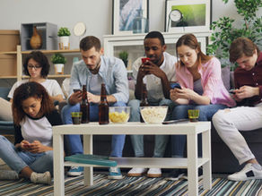 Group of people sitting together all looking at their phones, ignoring each other