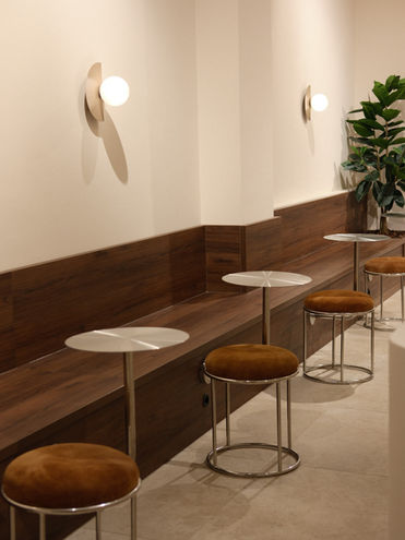 Minimalistisch horeca-interieur van Miro Amsterdam met houten maatwerk zitbank en designverlichting.
