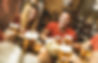 A man & women enjoying drinks at a pub with a group of people. They both have big smiles on their faces.