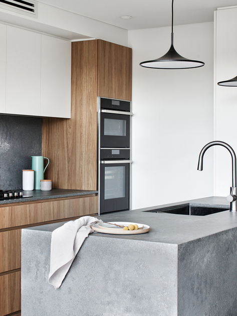 rugged concrete kitchen block island with sink, over-head pendant lights, custom bespoke joinery