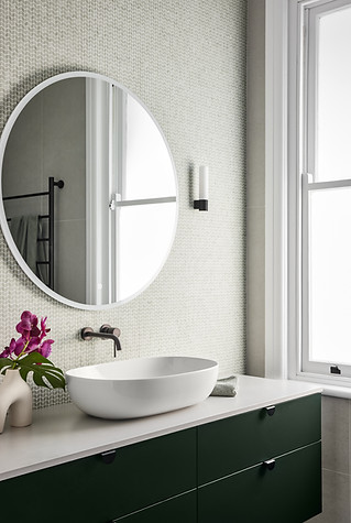 Dark green vanity, mini chevron mosaic tile, wall light