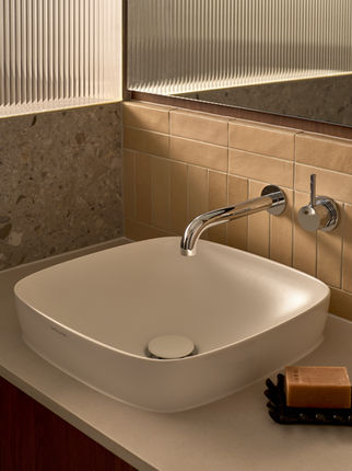 Contemporary bathroom vanity with timber cabinetry, terrazzo benchtop, ribbed glass screen, and neutral beige tiles.