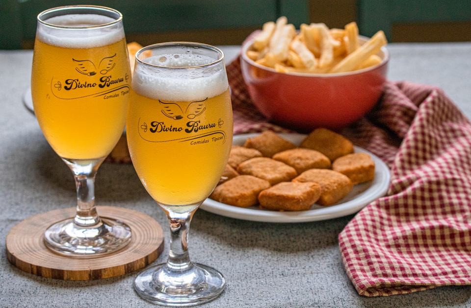 Duas taças de chopp a esquerda, com deliciosos queijinhos fritos e um bowl com batatas fritas.