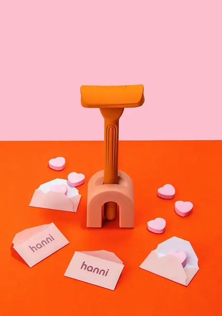 Minimalist commercial still life of Hanni razor with tiny props and hearts scattered around a minimalist product scene