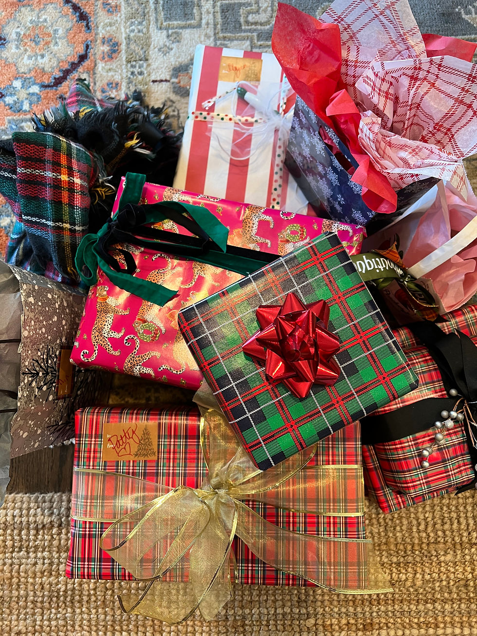 Colorful gifts with plaid, cheetah, and striped patterns sit on a patterned rug. They feature various bows and ribbons, exuding a festive mood.