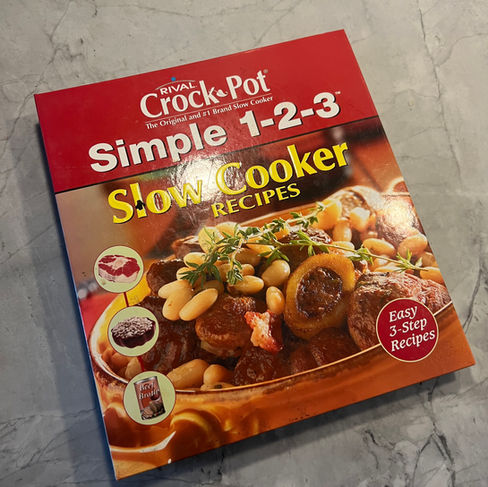 Cookbook titled "Crock-Pot Simple 1-2-3 Slow Cooker Recipes" with soup image. Features easy 3-step recipes. Red cover on marble surface.