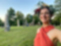 Woman in floral crown smiles near large stone sculptures