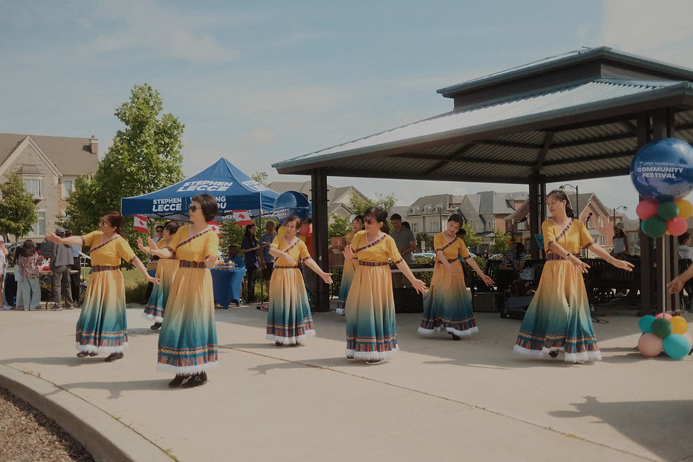 Eye-level view of a small live music performance at an outdoor community festival.