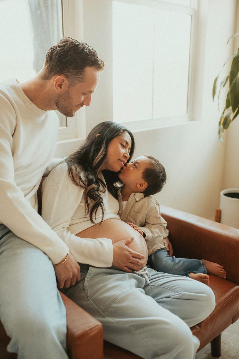 Couple snuggling on a couch with their toddler