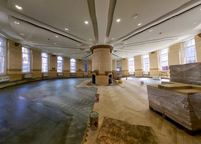 New solid oak herringbone parquet installation during restoration of a historic university building.