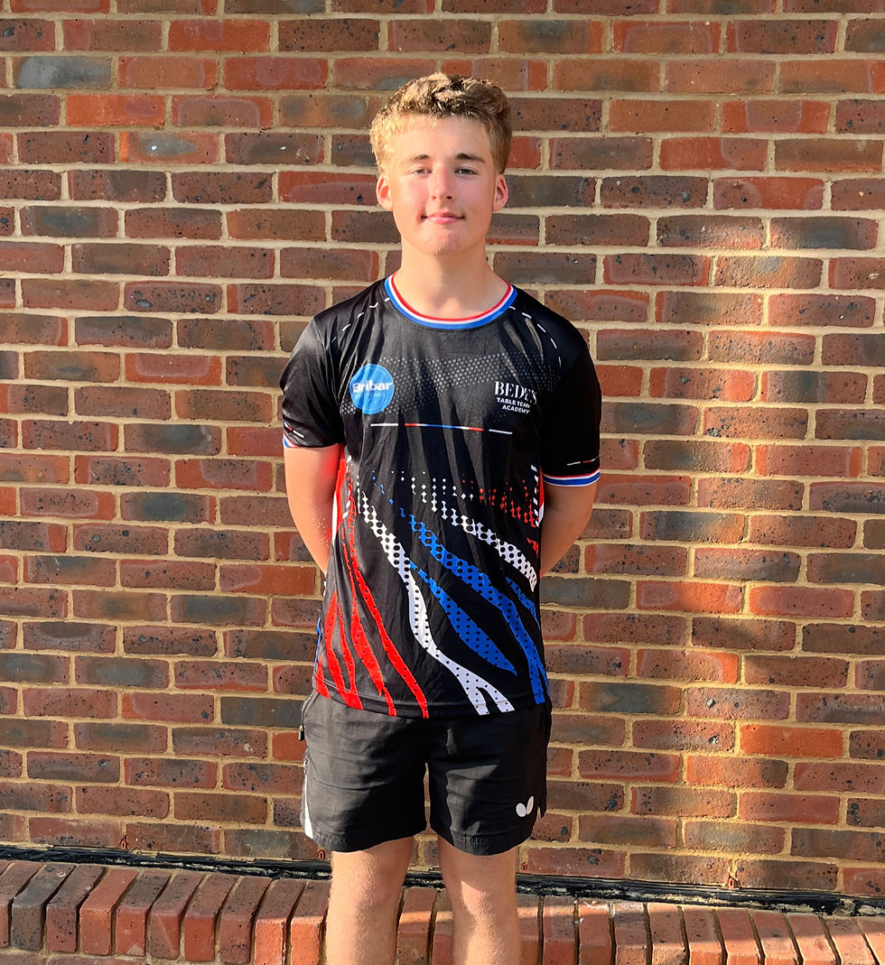 Young athlete in table tennis jersey standing by a brick wall