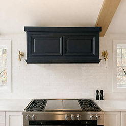 Custom wood range hood with built-in cabinetry in a luxury kitchen designed by Elusive Beauty Designs.