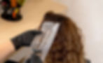 Eine Frau lässt sich ihre Haare strähnen beim Friseur