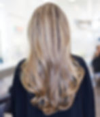 Eine Blonde Frau zeigt ihren Hinterkopf mit Balayage