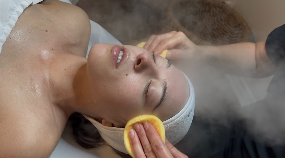 Client getting face cleansed and steamed during facial service