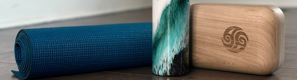 Block therapy equipment including a wooden fascia block, yoga mat, and water bottle in a wellness space.