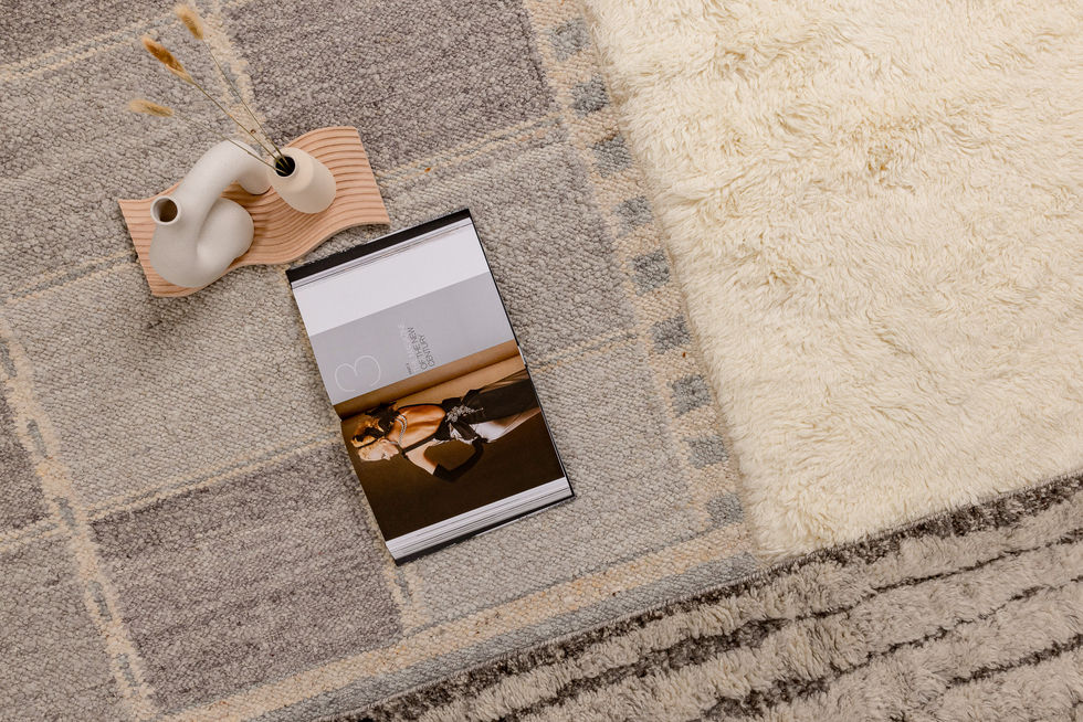Overhead still life photography of cream textured rug with book and ceramic styling | Commapix Studio