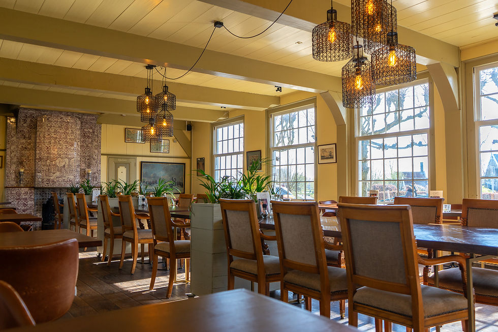 Restaurant interior with wooden chairs and hanging lamps at D'Swarte Walvis, Zaanse Schans