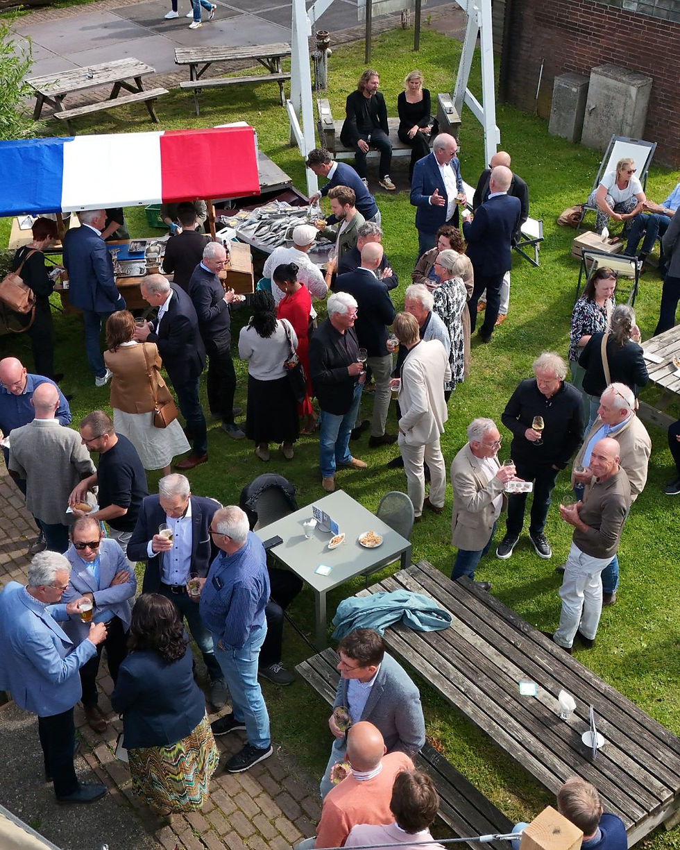 Gasten op de binnenplaats van LAB-44 tijdens een haring en seafood party