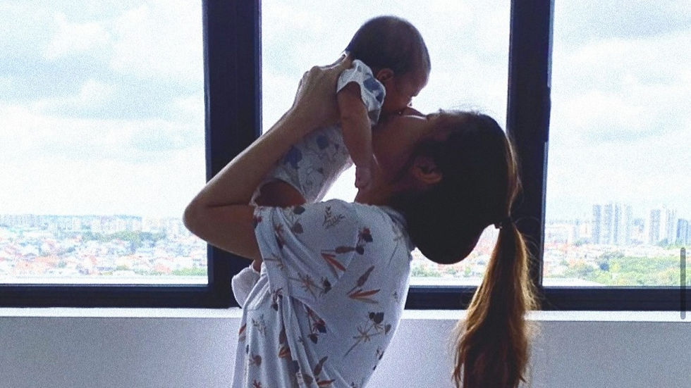 new mother in bamboo sleepwear kissing baby