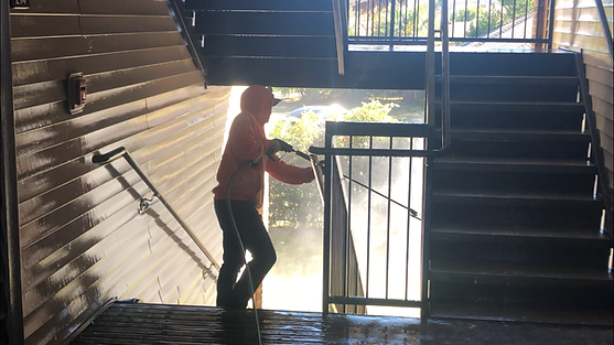 Apartment complex breezeway being pressure washed by a professonal power washer