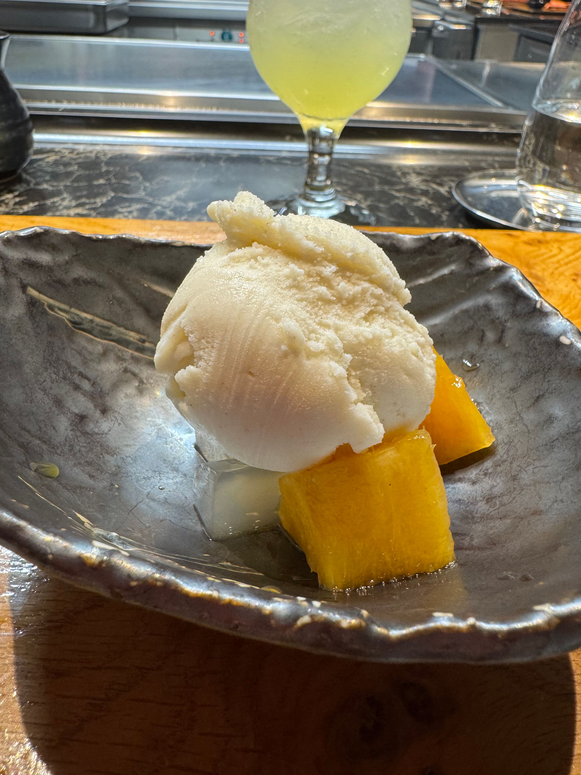 Desert of ice cream and mango on a plate.