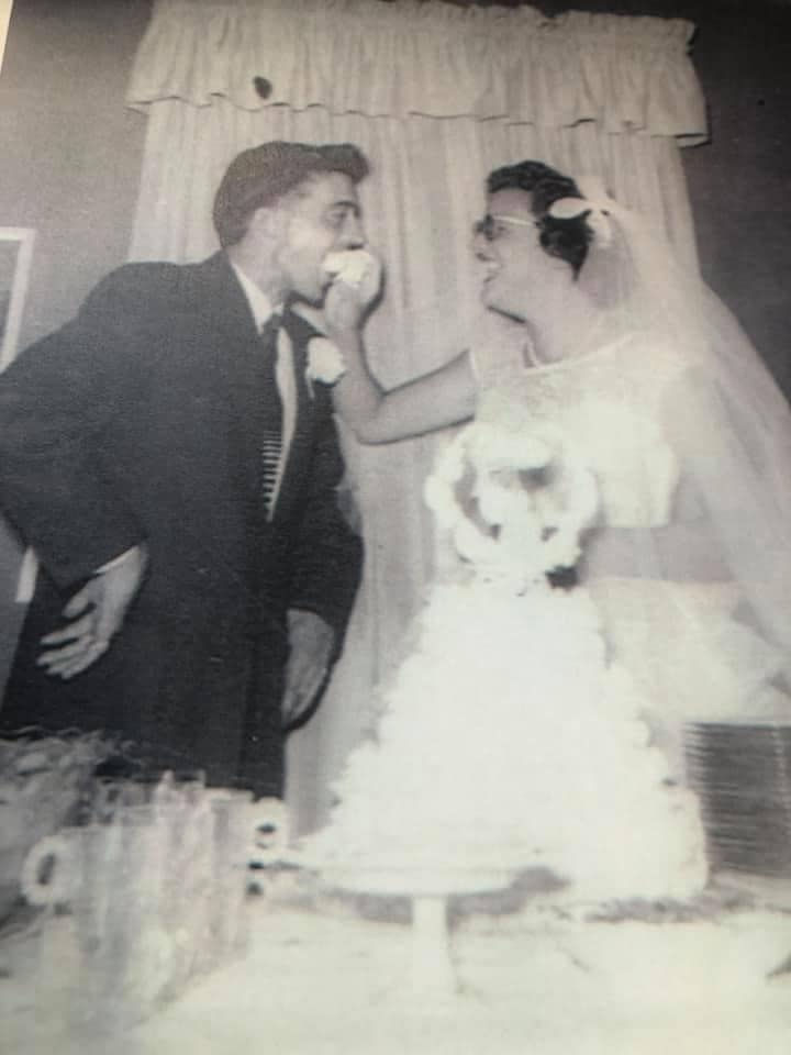 Couple on their wedding day feeding each other wedding cake.