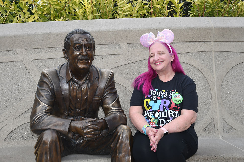 Picture of a woman sitting next to a statue of Walt Disney at the Epcot theme park in Walt Disney World.