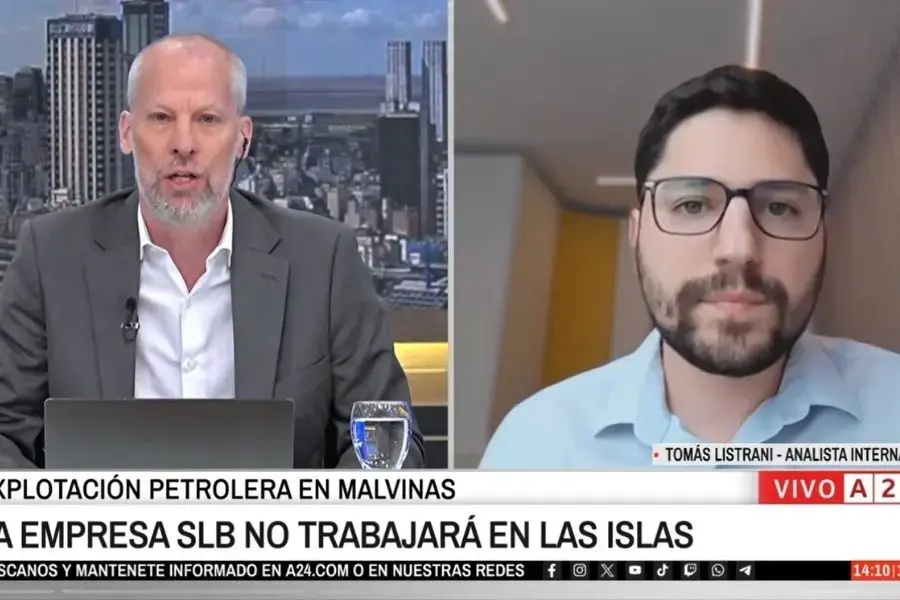 Dos hombres conversan por videollamada; uno está en un estudio de noticias y el otro en una oficina.