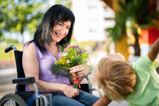 young-women-on-wheelchair-with-little-cute-boy-picture-id1053566046.jpg