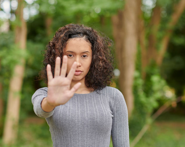 A woman with her hand held out in front of her representing strong boundaries