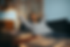Image shows a dressed in laying on her couch with set of headphones looking relaxed