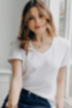 Femme assise de face portant le tee-shirt AARON blanc, col V, 100% coton bio