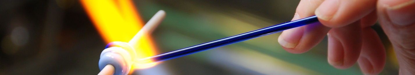 Melting glass rods in an intense flame lampwork or flamework