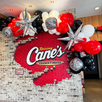 Custom branded balloon wall featuring Raising Cane’s event decor in Baton Rouge