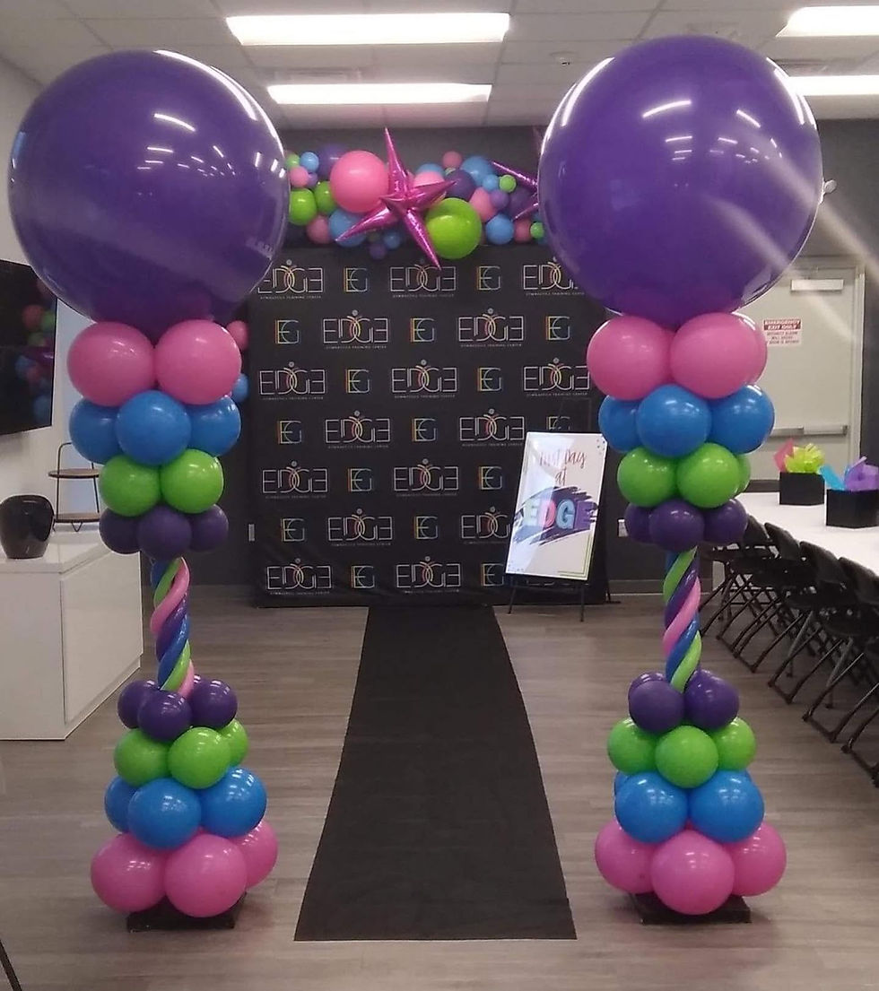Two purple, pink, blue and green columns opposite of each other with a rug down the middle for photo with a backdrop.