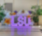 Purple LSU letters with LED lights outlining the LSU. White balloon garland around the LSU sitting on the floor for an LSU event in Baton Rouge.