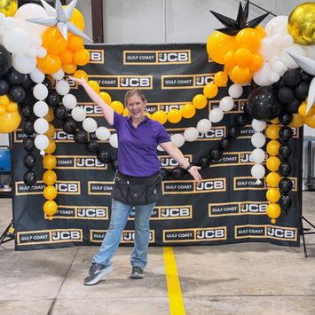 Black, gold, and white event backdrop with balloon columns for a branded Baton Rouge event