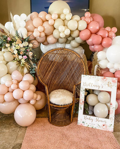 Peach and blush balloon backdrop with chair setup for a baby shower or birthday in Baton Rouge